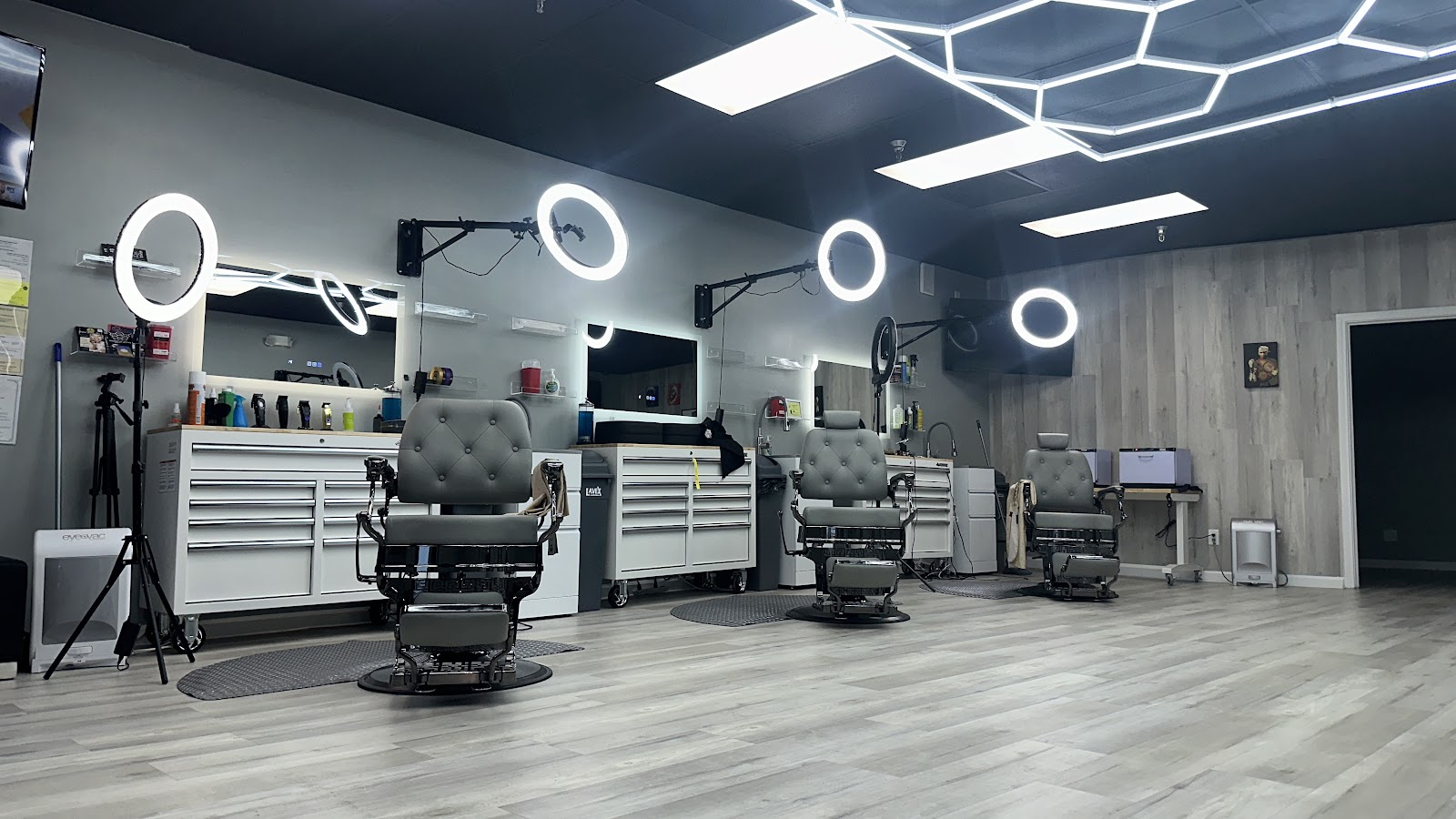 Barbershop interior with three chairs, ring lights and stations