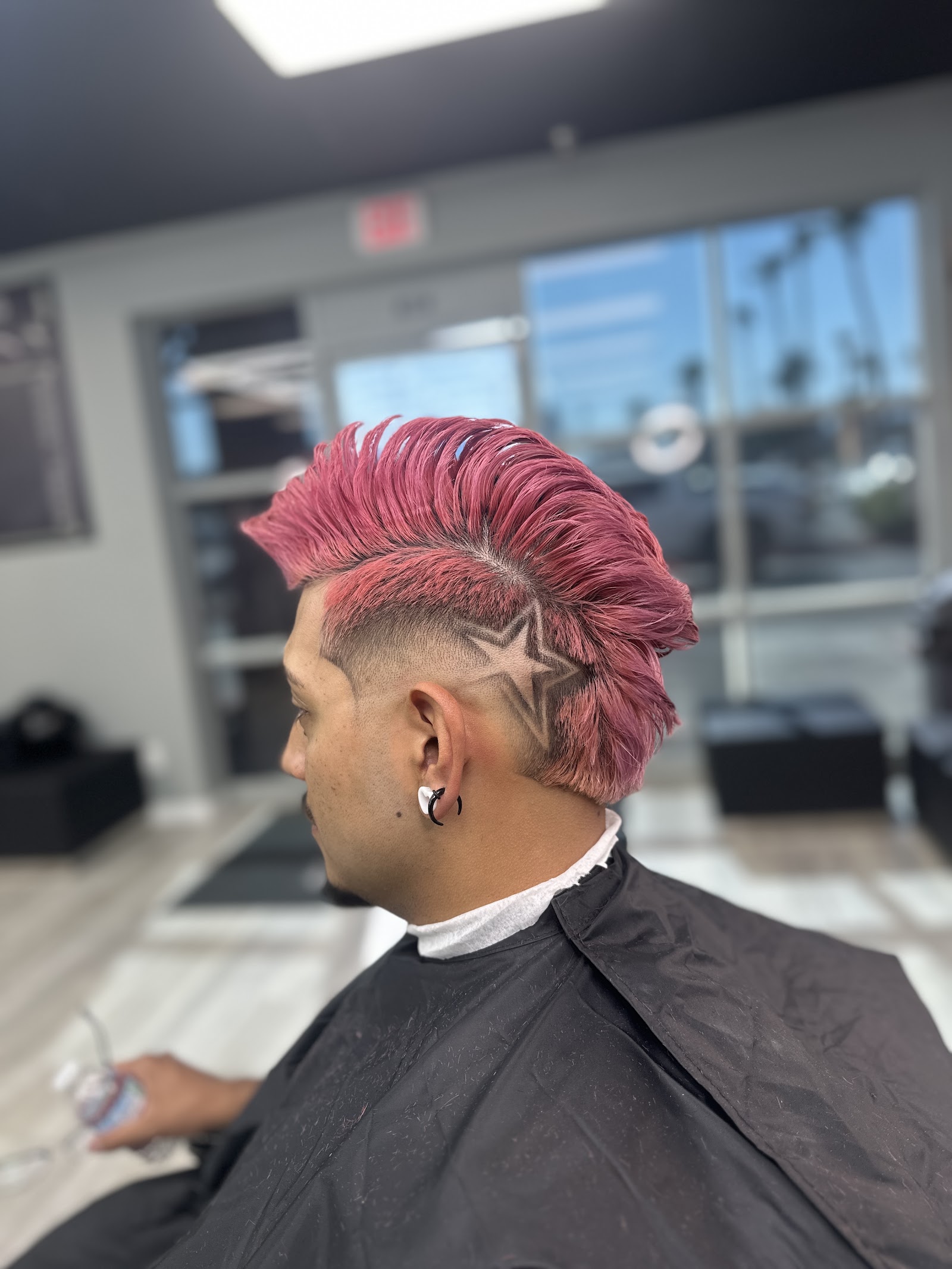 Pink-dyed mohawk with star hair design and clean fade