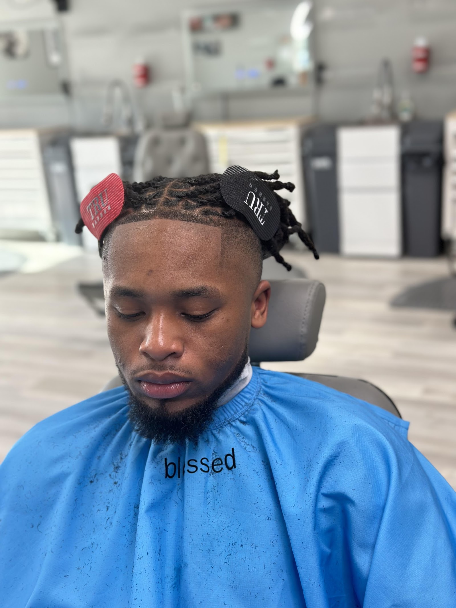 Client with fresh fade, locs styled and clean beard line at the shop